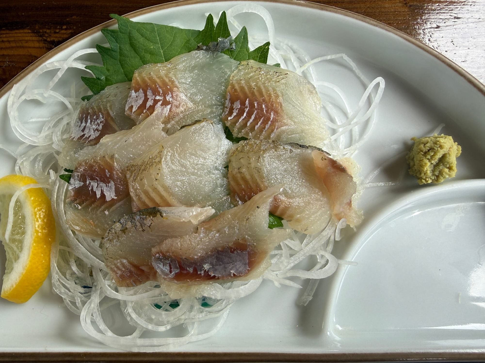 大葉、つま、レモンと一緒に盛られた鮎の刺身