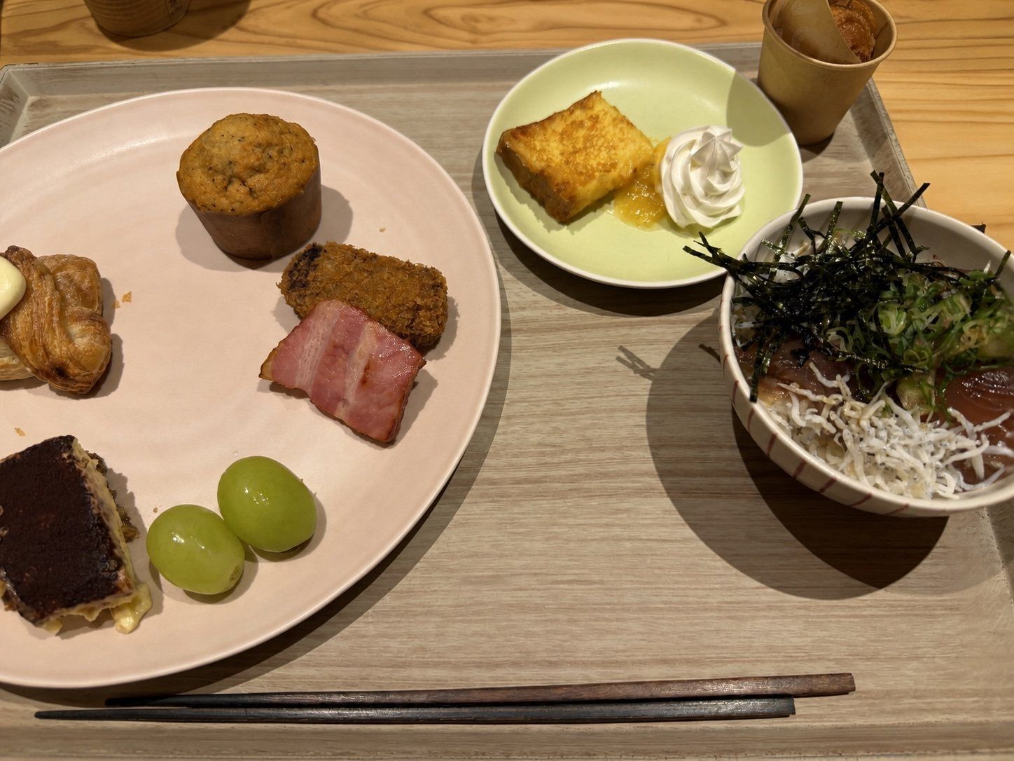 カツオの漬け丼、パン、果物、デザートを盛り付けた朝食
