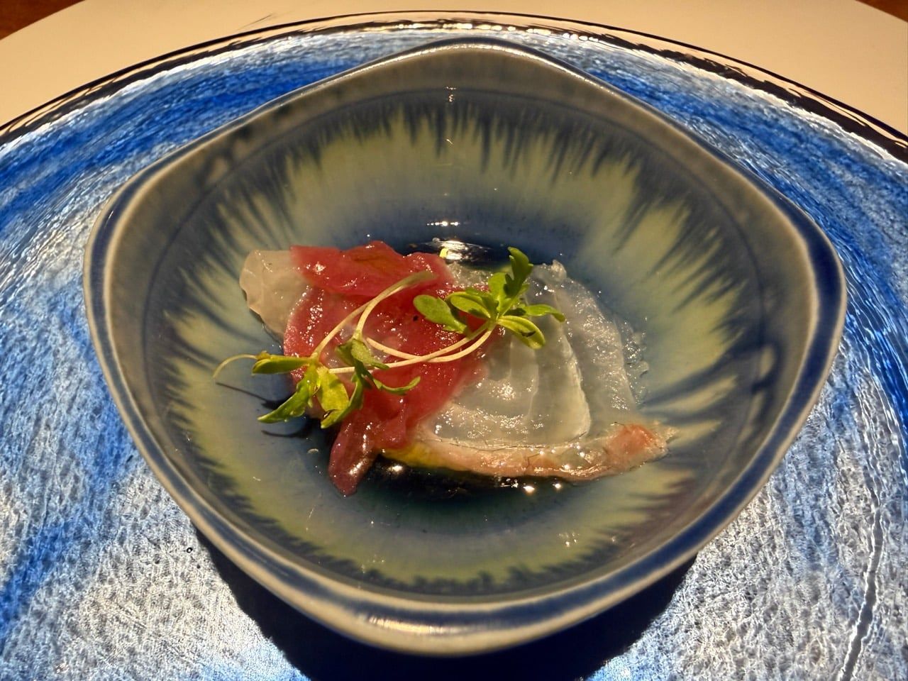 青い器に盛られた赤身と白身の魚料理