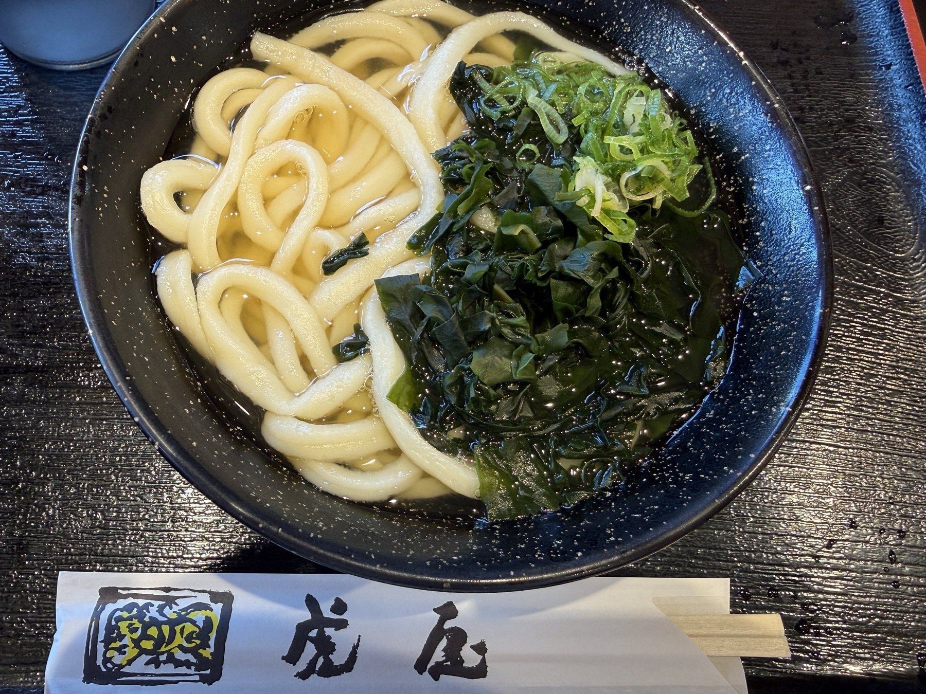 わかめとねぎがのった温かい讃岐うどん